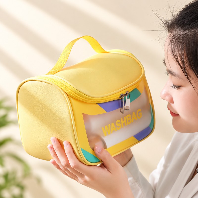 Trousse de toilette femme transparente jaune, tenue en main